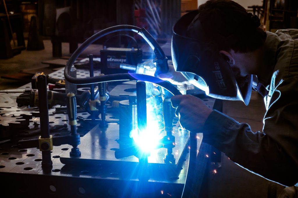 Close up picture of an employee welding in the C G Fabrication shop.