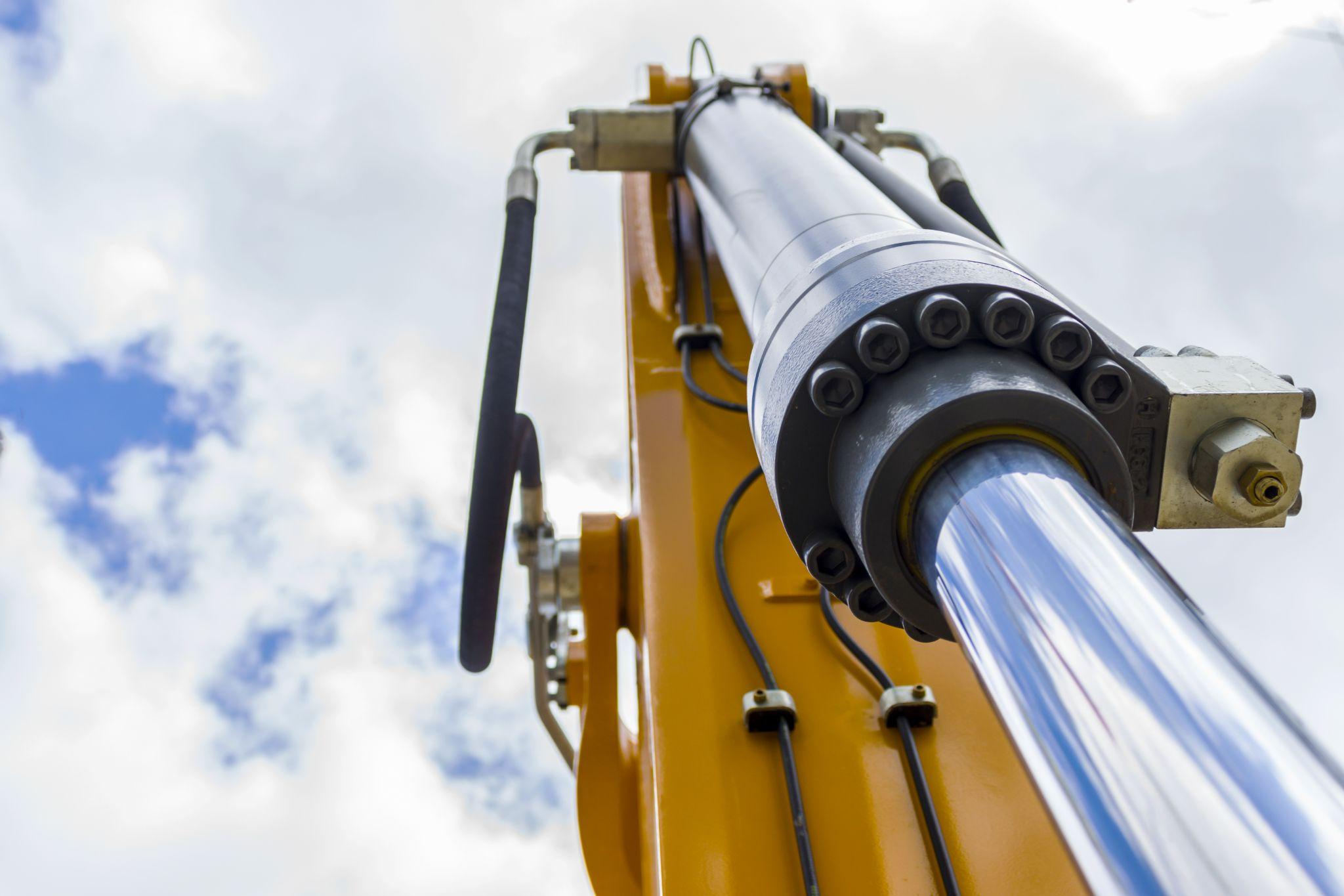 Close-up of a heavy-duty hydraulic cylinder on excavator arm — precision fabrication in Liberty, KY